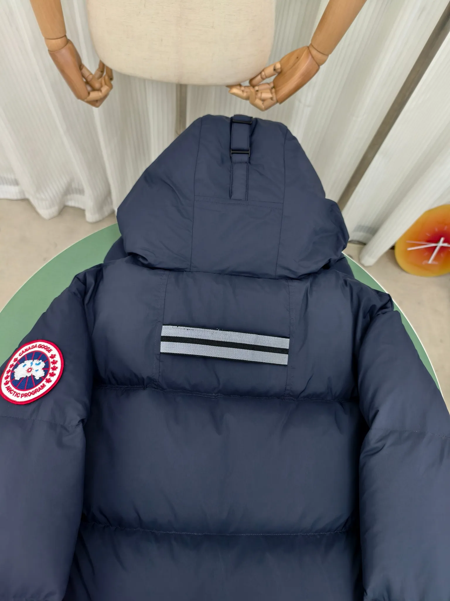 P940 Canada Goose Lawrence Down Jacket The Lawrence Down Jacket provides essential protection for everyday adventures and is made from sustainable Enduraluxe fabric with a durable soft touch. It features a quilted body, an adjustable down hood and a longer hem. Adjustable, down-filled, communicated hood. Two-way center front zipper increases range of motion and ventilation. The chin-protecting suede knit stand-up collar is soft and extra-comfortable. Inset rib-knit cuffs for added comfort and locked in heat. CORDURAD piping at the cuffs hem and reflective double-stripe grip tape at the back. Internal shoulder strap Color: black with red label black with black label azure blue Size: XS-2XL